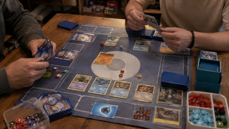 Balíček karet Pokémon TCG s energetickými kartami rozloženými na stole při přípravě partie